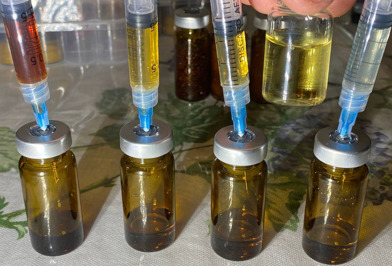Reconstituted NAD from the group buy shows materially different colors in clear syringes, ranging from nearly colorless to dark amber.